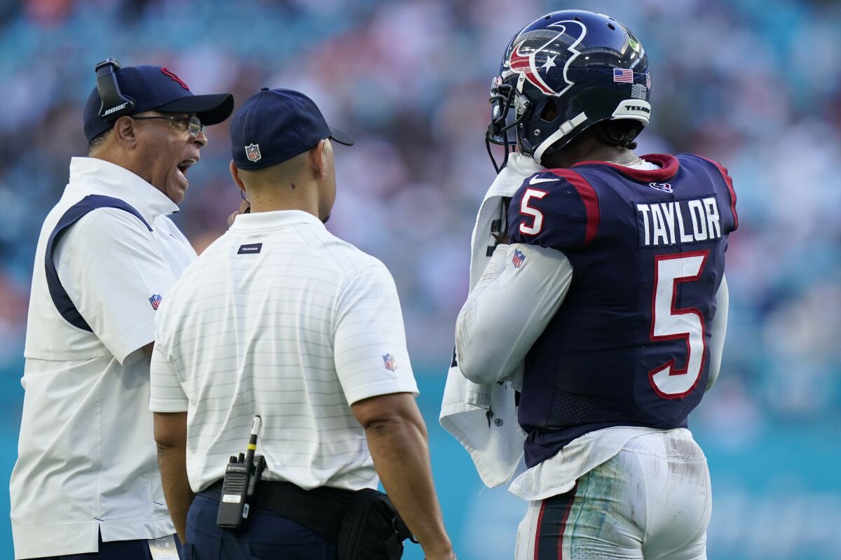 Houston Texans head coach David Culley talks to quarterback Tyrod Taylor (5) on the sidelines during the second half of an NFL football game against the Miami Dolphins, Sunday, Nov. 7, 2021, in Miami Gardens, Fla. (AP Photo/Lynne Sladky)