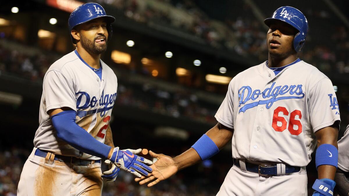 Dodgers outfielder Matt Kemp, left, is congratulated by teammate Yasiel Puig after hitting a run-scoring double against the Arizona Diamondbacks on Aug. 27. Kemp and Puig appeared to get into an argument during Monday's win over the Colorado Rockies.