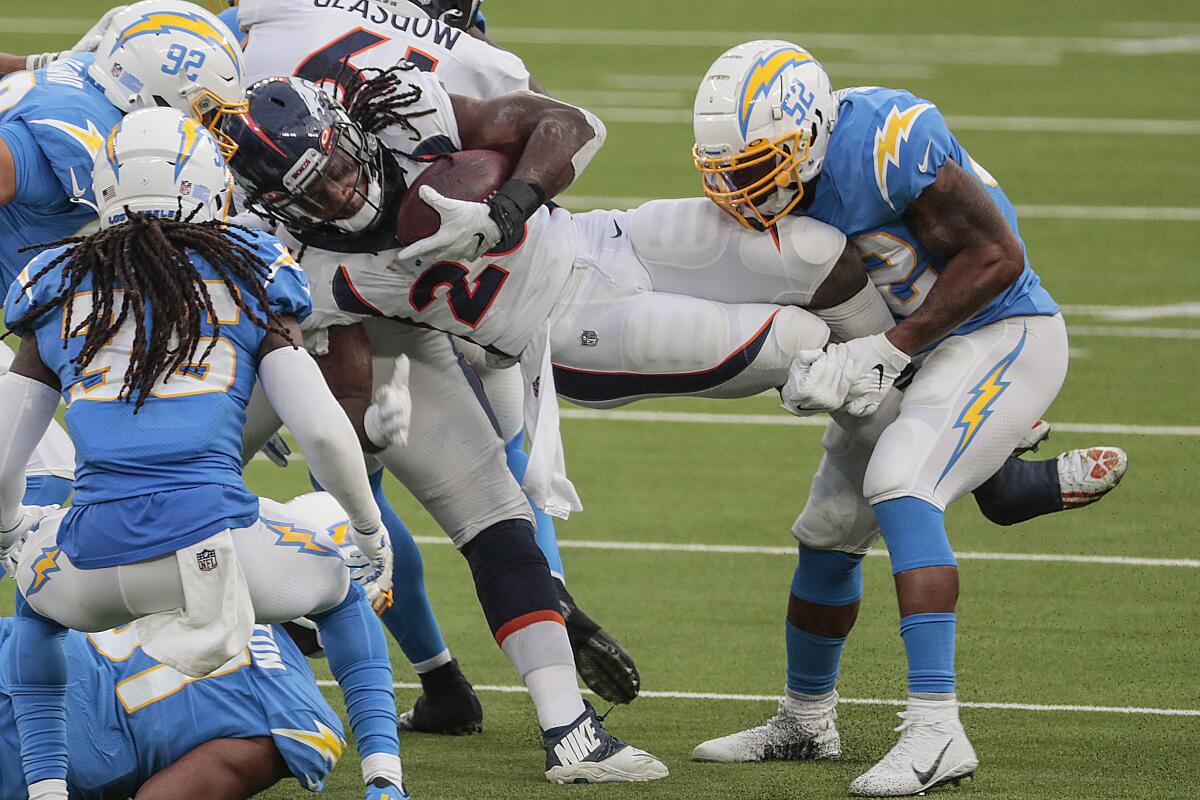 Denver Broncos running back Melvin Gordon is tackled by Chargers middle linebacker Denzel Perryman during the second half.