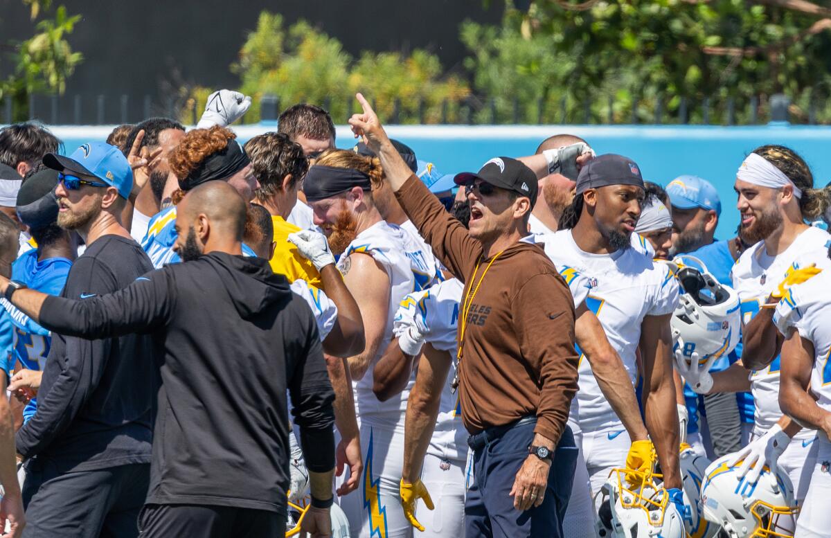 Chargers coach Jim Harbaugh shouts to the team at the end of a mini camp workout
