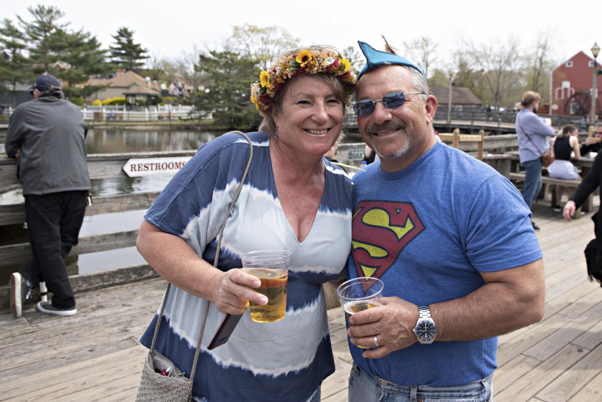 FILE - In this April 24 2021, file photo, Lisa and Mike Smurro pose for a photo at the annual Renaissance Faire, in Smithville, N.J. Smurro, a New Jersey vice principal who was filmed tossing a cup of beer at people who had been recording his wife's rant against an apparent transgender woman's use of a public restroom is suing them for defamation, asserting he never said a word about transgender issues. (Matthew Strabuk/The Press of Atlantic City via AP, File)