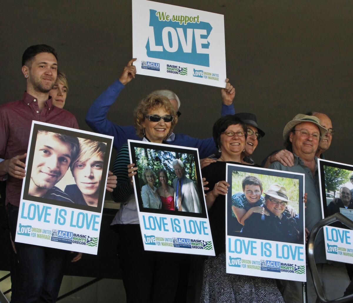Supporters of same-sex marriage hold photos of themselves and their family members or partners at a federal courthouse in Eugene, Ore., last week.