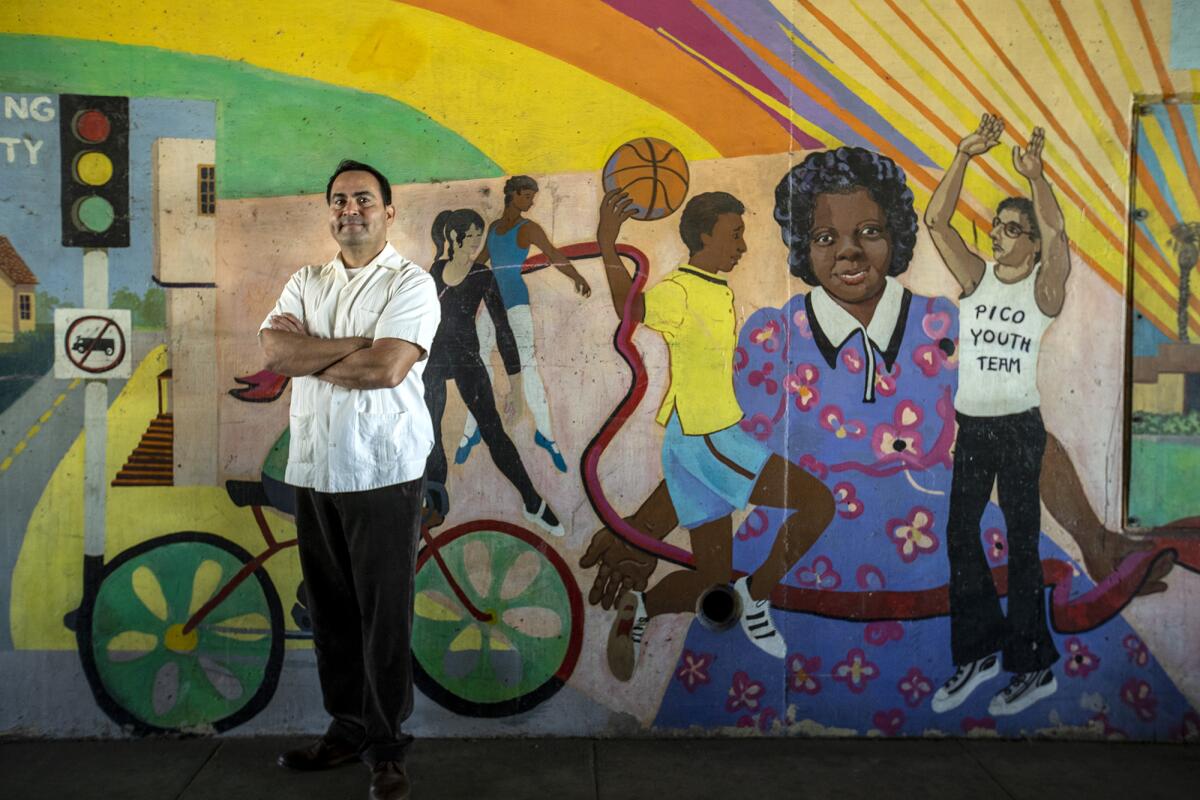 Santa Monica Councilman Oscar de la Torre stands at a mural featuring community leader Thelma Terry.