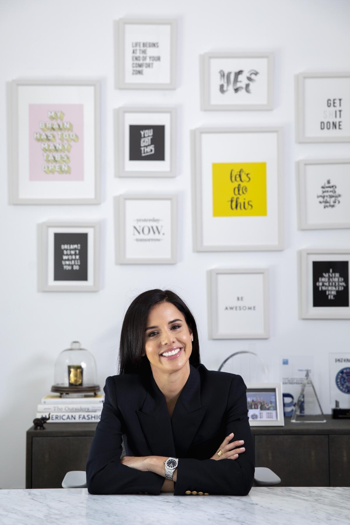 A woman sits at a desk.
