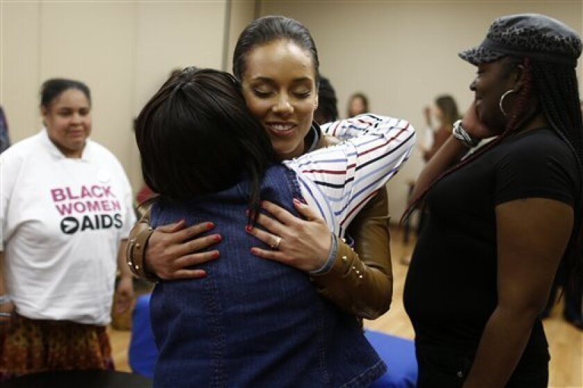 Grammy Award-winning singer Alicia Keys hugs HIV positive woman as she visits an HIV women's support group at United Medical Center in Washington, Monday, April 15, 2013. Keys is working with the Kaiser Family Foundation for "Empowered," a campaign launched last month to educate women about HIV/AIDS and provide grants to community based projects that will do that. (AP Photo/Charles Dharapak)