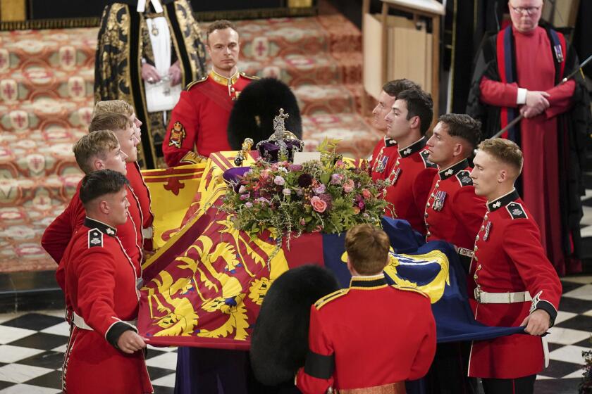 Pallbearers adjust the Royal Standard as the coffin of Britain's Queen Elizabeth II arrives for a committal service at St George's Chapel, Windsor Castle, in Windsor, England, Monday, Sept. 19, 2022. (Joe Giddens/Pool Photo via AP)