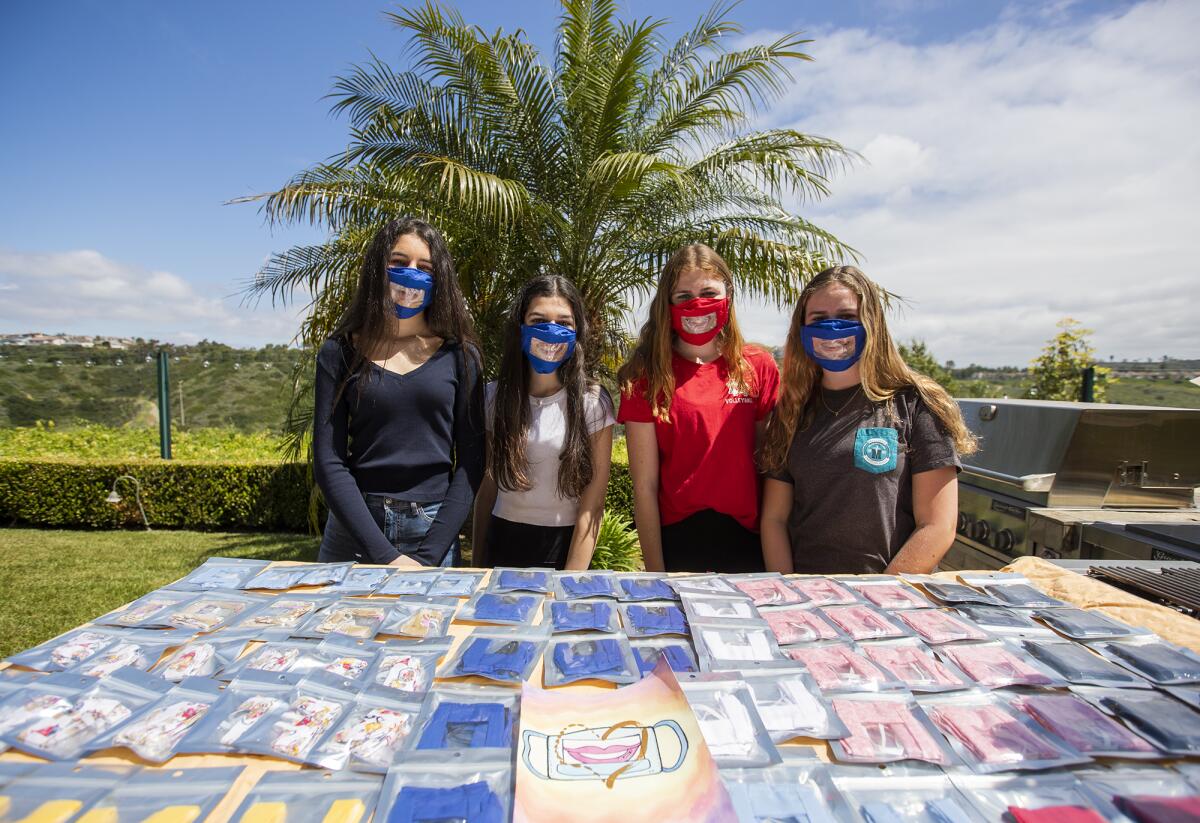 Hannah and Isabelle Dastgheib, left, 15 and 16, and Maggie and Kate Dietrick, 14 and 16, have designed masks with a clear plastic window in the middle so those who are hard of hearing can see their mouths.