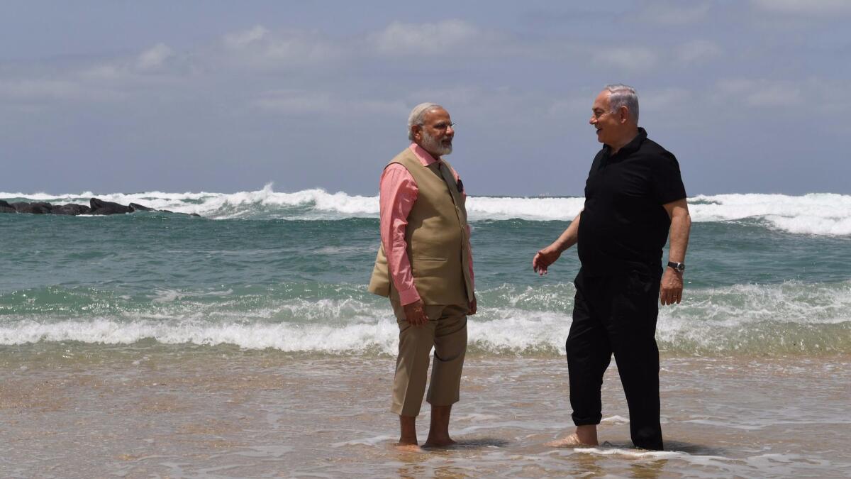 Indian Prime Minister Narendra Modi, left, and Israeli Prime Minister Benjamin Netanyahu visit Olga Beach in Israel on Thursday.