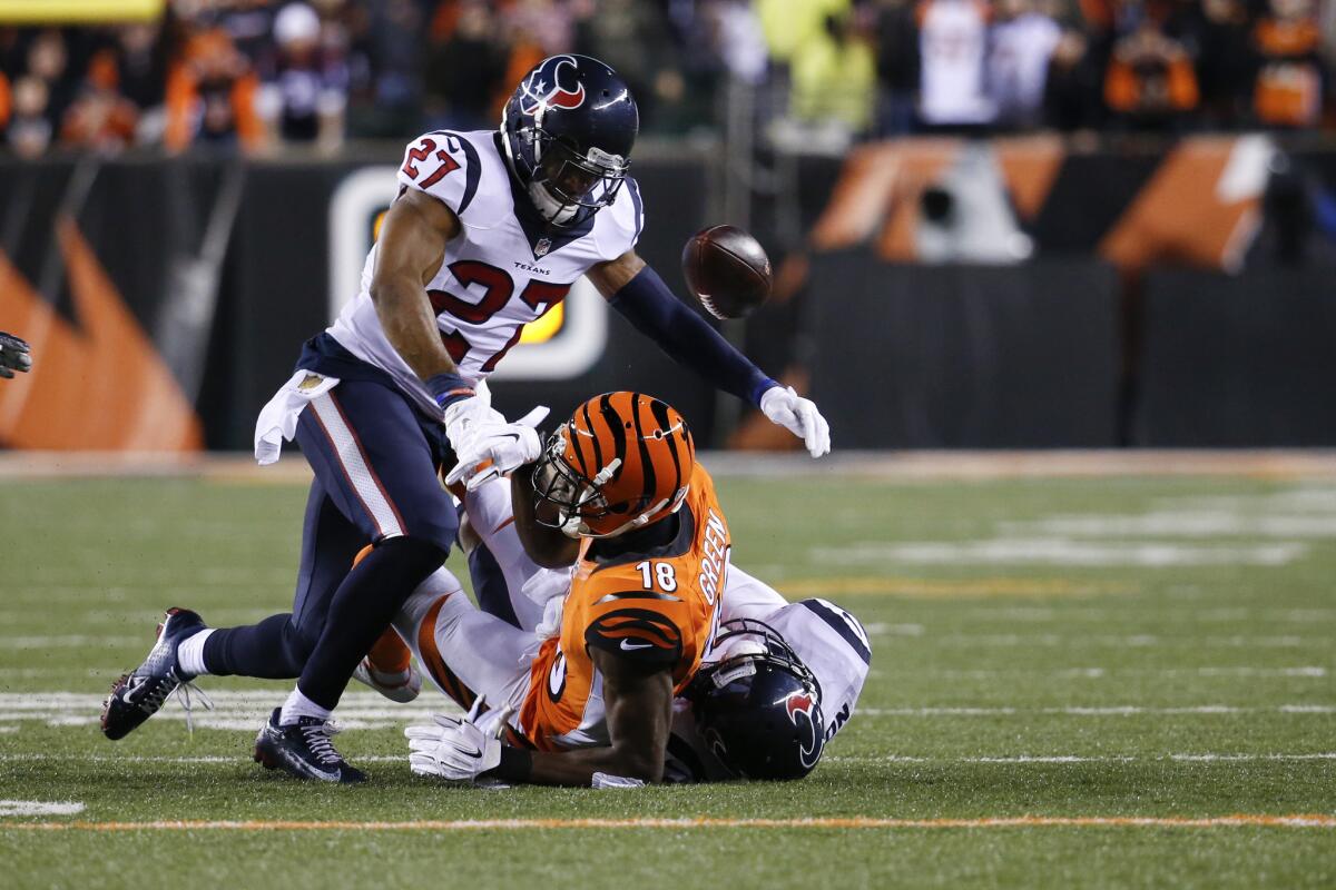Bengals wide receiver A.J. Green (18) fumbles the ball as he's tackled by Texans defenders Quintin Demps (27) and Kevin Johnson in the second half.