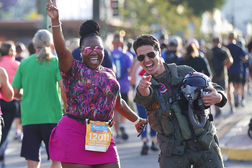 SAN DIEGO, CA - OCTOBER 24: Jerome LeBlanc, dressed as Tom Cruise's character Maverick from Top Gun, entertains runners during the Rock 'n' Roll Marathon and Half in North Park on Sunday Oct. 24, 2021 in San Diego, CA. (K.C. Alfred / The San Diego Union-Tribune)