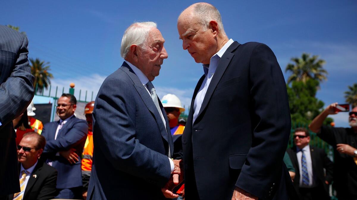 California Transportation Commission member Joseph Tavaglione, left, and Gov. Jerry Brown greet before a press conference in Riverside on April 4 to discuss a proposed gas tax increase.