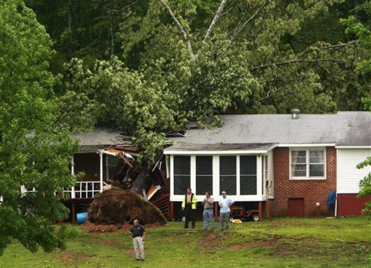 A tree rests on Larry Carson's house causing extensive damage after it fell during a storm Wednesday, May 6, 2009 in Tuscaloosa County, Ala. A storm front with severe weather settled across the South on Wednesday with heavy rains, a possible tornado in Alabama and damage to about 100 homes throughout the region. (AP Photo/The Tuscaloosa News, Michael E. Palmer)