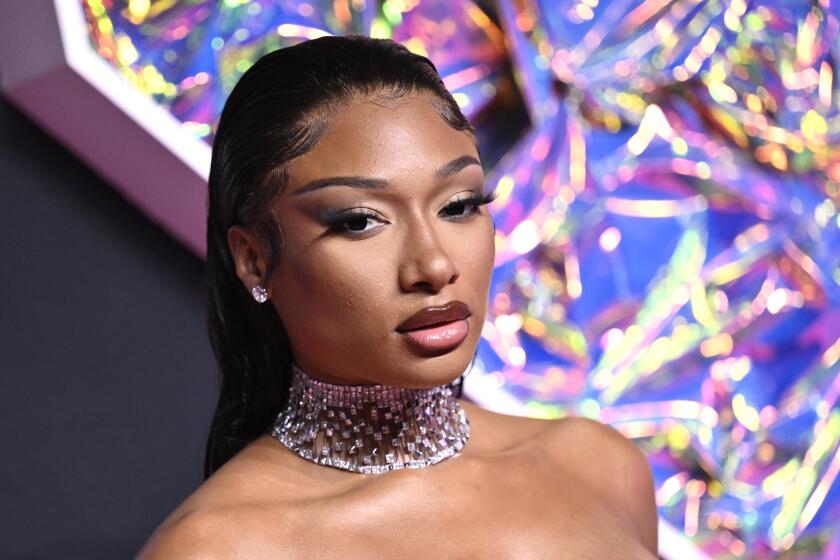 Megan Thee Stallion poses in a sparkly choker and diamond stud earrings.