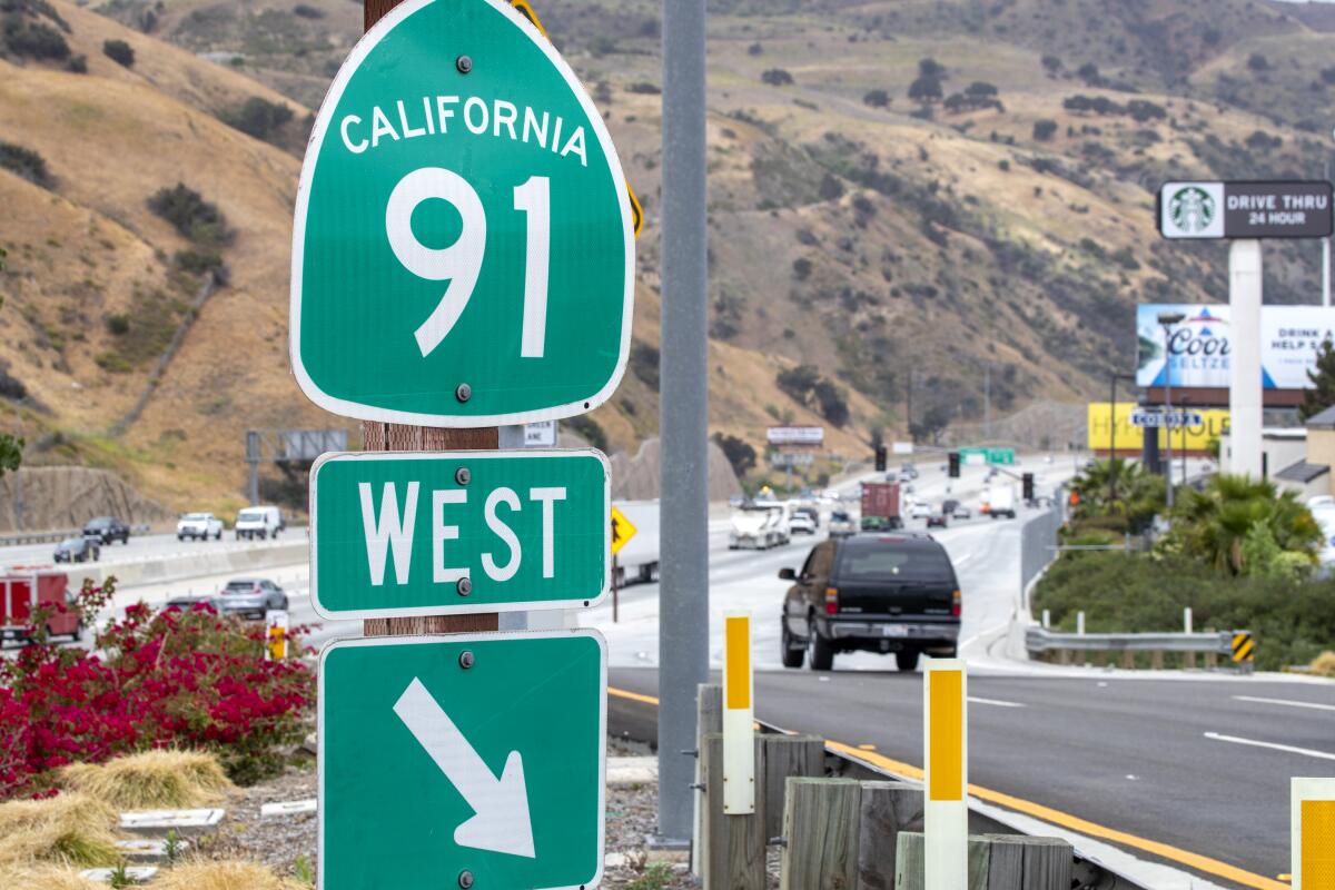 A 91 Freeway sign next to traffic on the freeway