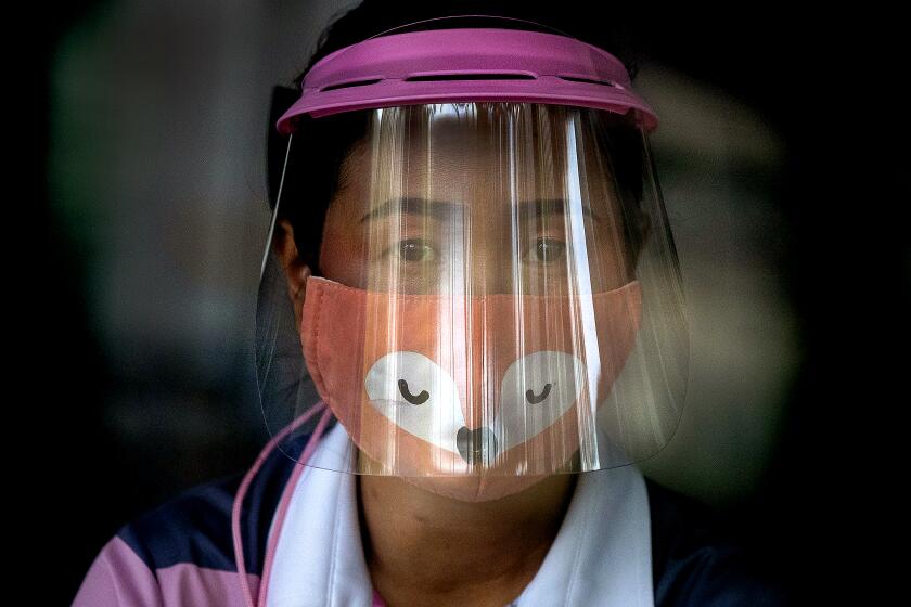 THAILAND: A volunteer wearing a face shield and mask manages a counter of COVID-19 infection screening center at the Chulalongkorn University health service center in Bangkok, Thailand.