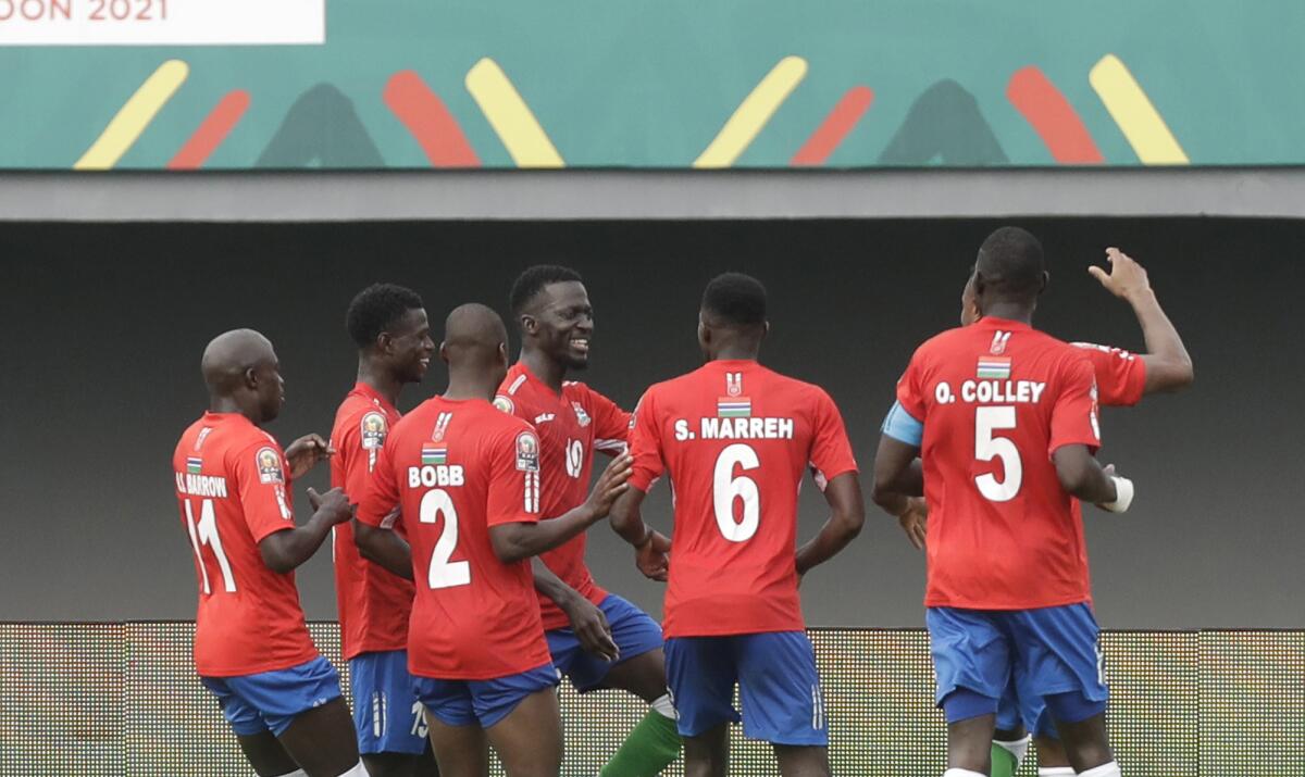 Gambia's players celebrate after teammate Musa Barrow scored his team's first goal, during the African Cup of Nations 2022 group F soccer match between Gambia and Mali at Omnisport Stadium in Limbe, Cameroon, Sunday, Jan. 16, 2022. (AP Photo/Sunday Alamba)