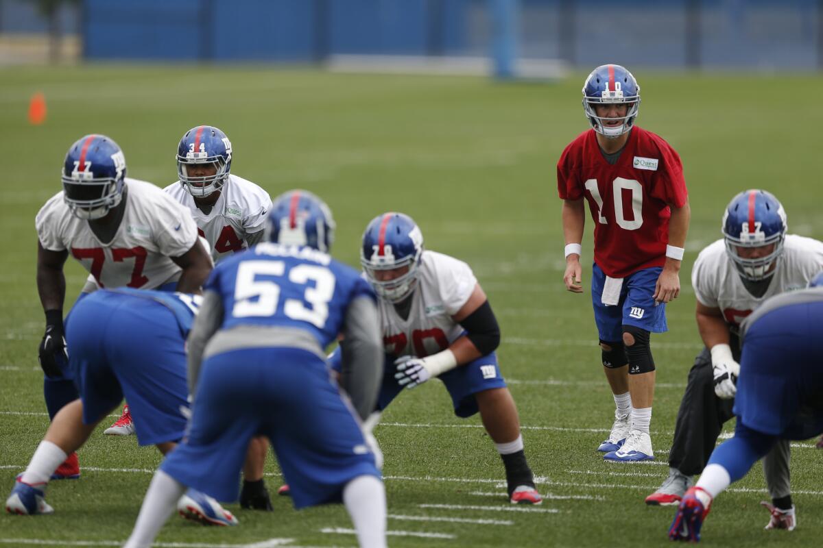 New York Giants quarterback Eli Manning runs a play during an organized team activity on May 27.