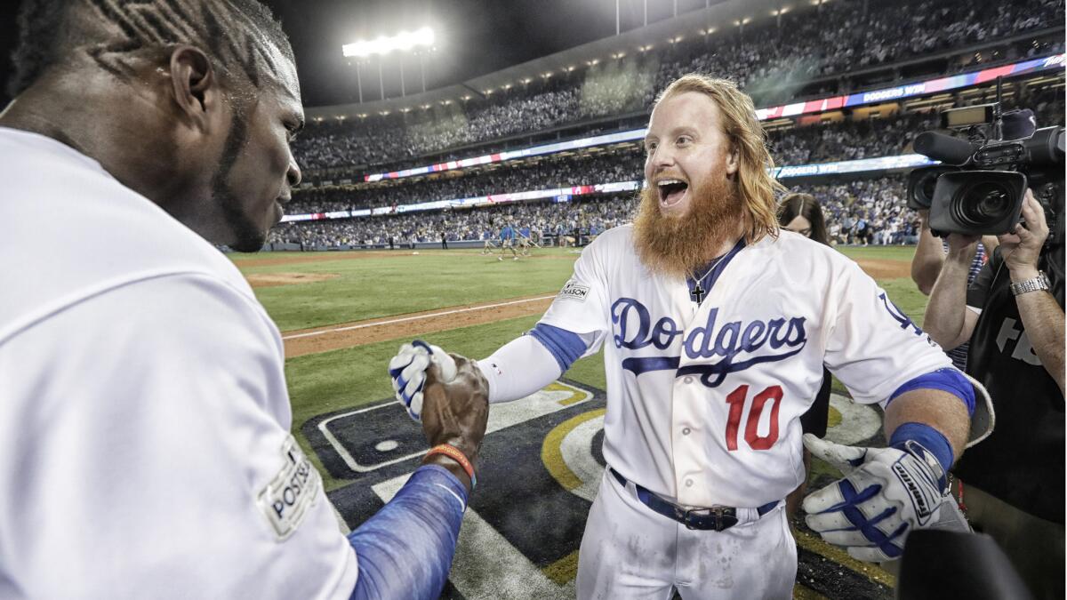 A jubilant Justin Turner celebrates with Dodgers teammate Yasiel Puig after hitting a walk-off, three-run homer to beat the Chicago Cubs 4-1 in Game 2 of the NLCS at Dodger Stadium on Oct. 15.