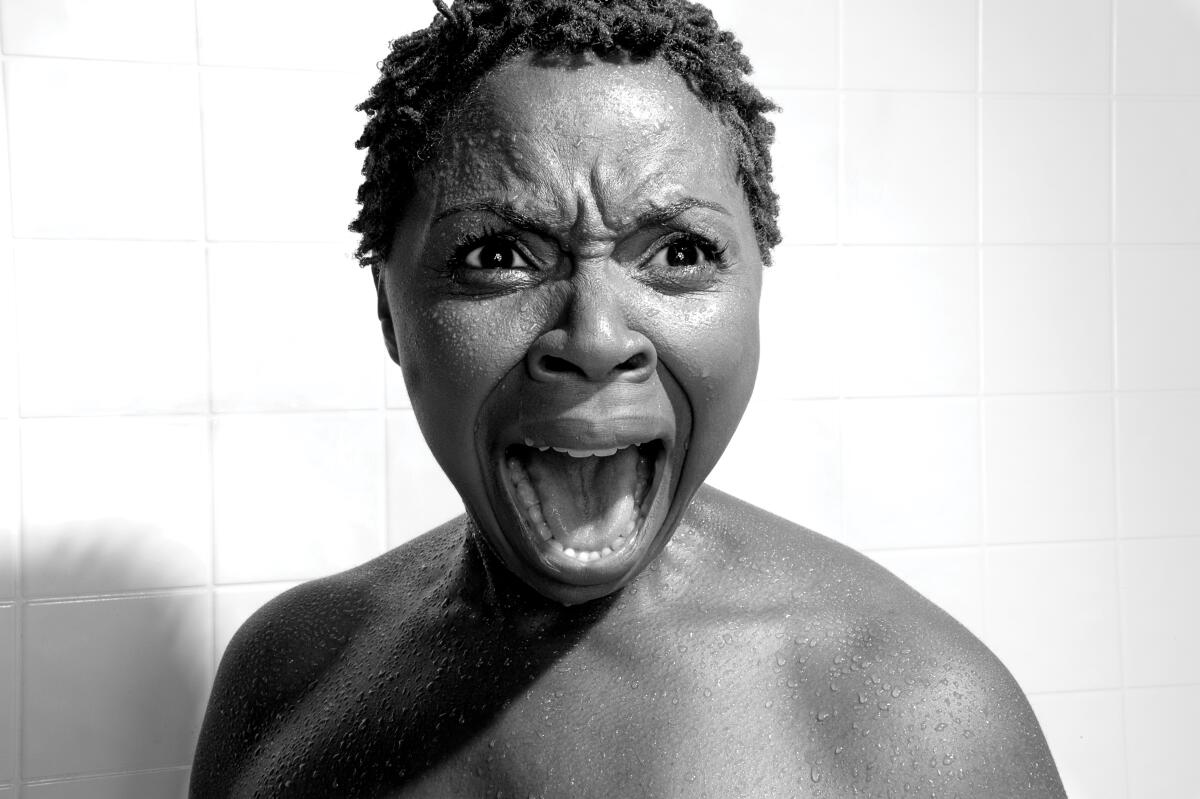 A woman with short hair standing in a shower and screaming a la Janet Leigh in "Psycho"