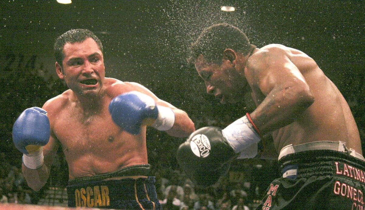 El boxeador Óscar de La Hoya golpea con fuerza a Ricardo Mayorga para dejarlo fuera de combate en el sexto asalto de su combate del Campeonato de la WBC de peso mediano.
