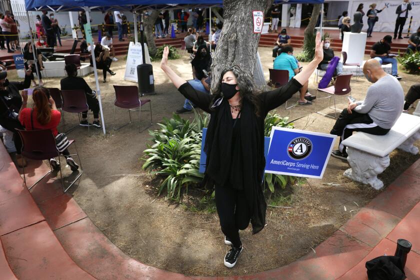 LOS ANGELES-CA-MARCH 22, 2021: Laurie Ginsburg, 58, of Santa Monica, dances after receiving her second dose of the Covid-19 vaccine at Kedren Community Health Center in South Los Angeles on Monday, March 22, 2021. (Christina House / Los Angeles Times)