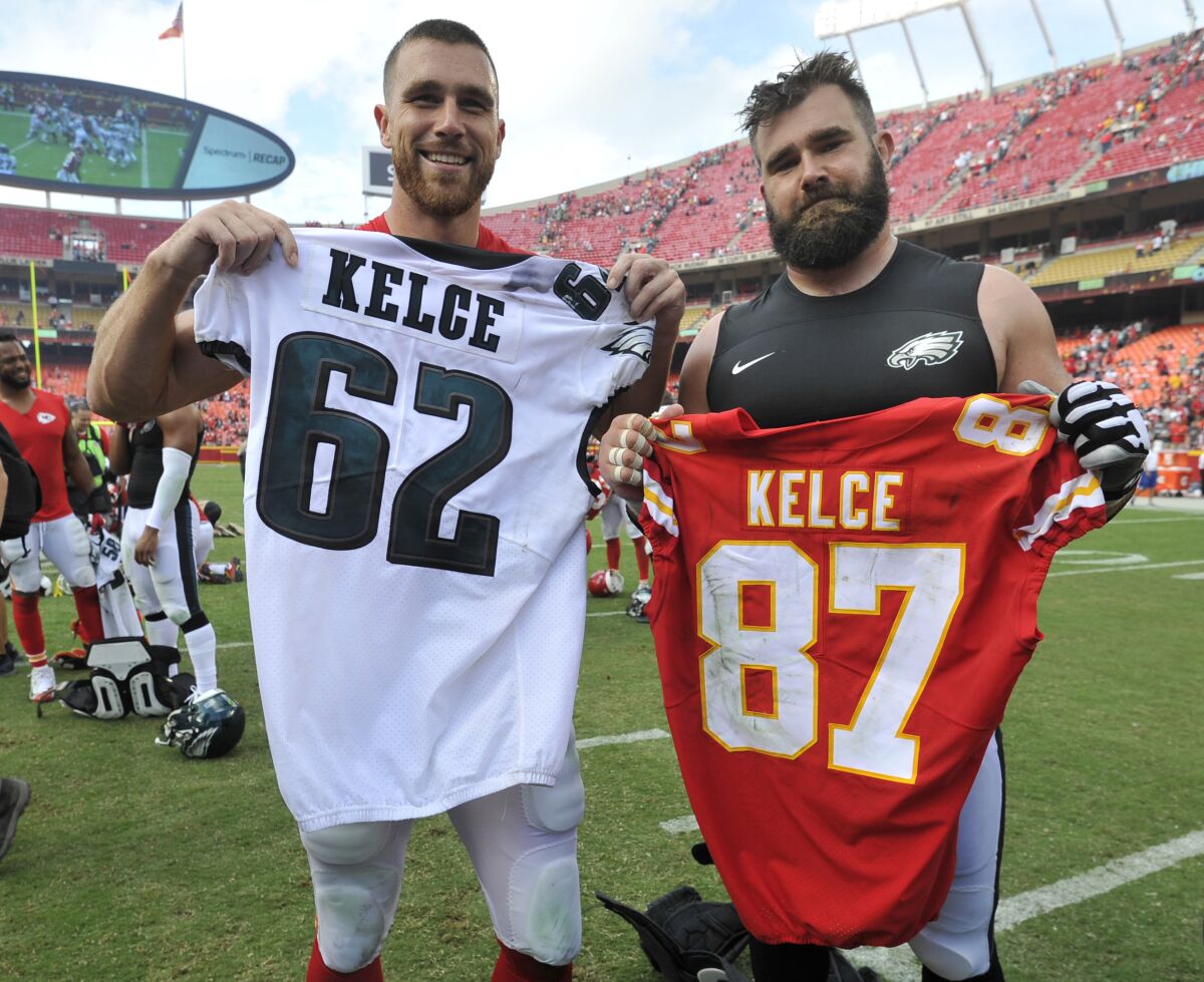 Travis and Jason Kelce hold each other's jerseys.