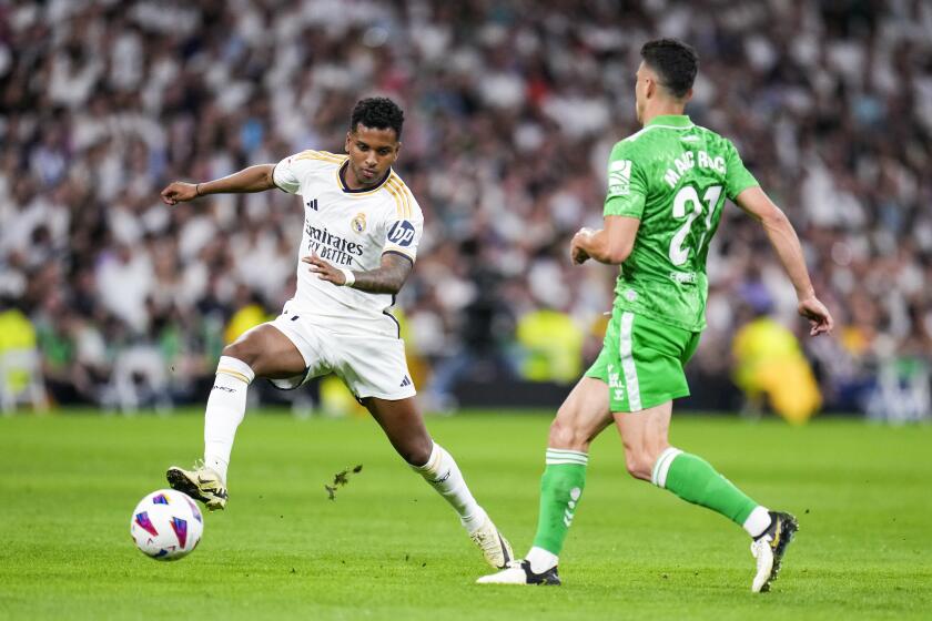 Real Madrid's Rodrygo, left, fights for the ball with Betis' Marc Roca during a Spanish La Liga soccer match between Real Madrid and Betis at the Santiago Bernabeu stadium in Madrid, Spain, Saturday, May 25, 2024. (AP Photo/Manu Fernandez)