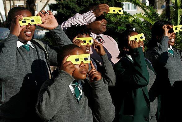 Children view the solar eclipse through special protective glasses in Cape Town, South Africa. A solar eclipse occurs when the moon passes between the sun and Earth so that the sun is wholly or partially obscured. Monday's partial eclipse was visible in the southern third of Africa, southeastern India, southeast Asia and the western part of Australia.