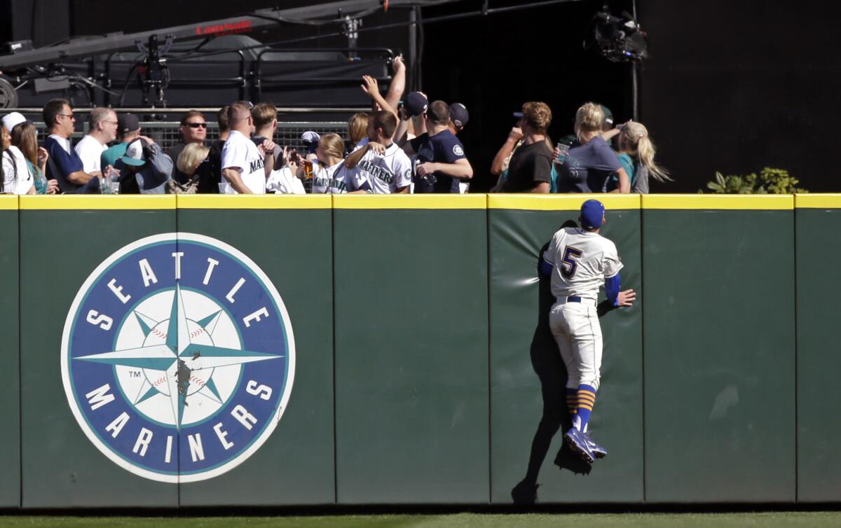 Seattle Mariners center fielder Brad Miller watches fans reach for the home run ball of Oakland Athletics' Mark Canha in the third inning of a game on Oct. 4.