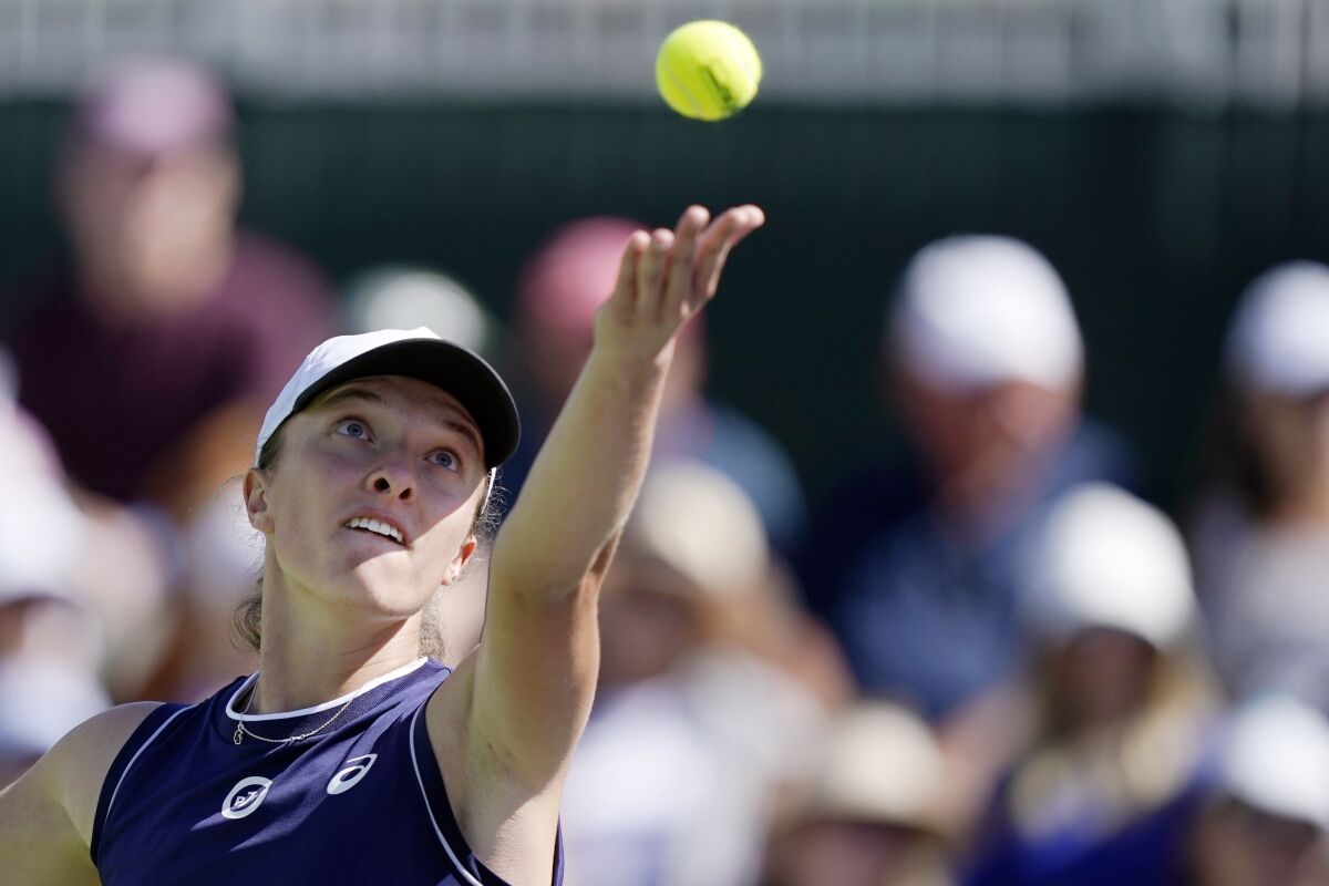 FILE - Iga Swiatek, of Poland, serves to Jelena Ostapenko, of Latvia, at the BNP Paribas Open tennis tournament, on Oct. 12, 2021, in Indian Wells, Calif. Swiatek says she is splitting from coach Piotr Sierzputowski after nearly six years working together. (AP Photo/Mark J. Terrill, File)