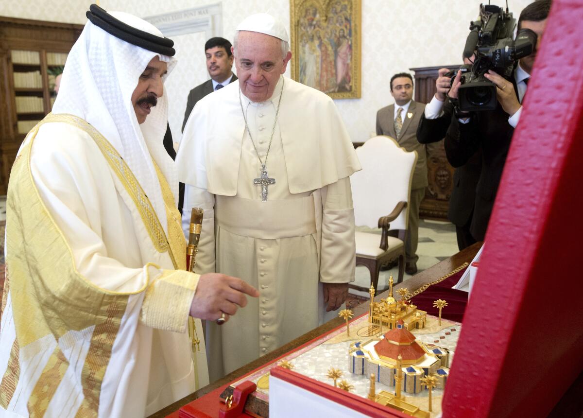 FILE - Pope Francis, right, is presented with a scale model of the building project of the biggest Catholic church in the Gulf region, by Bahrain's King Hamad bin Isa Al Khalifa during a private audience at the Vatican, Monday, May 19, 2014. Pope Francis is making the first-ever papal trip to Bahrain between Nov. 3-6, 2022, sparking calls from the country’s majority Shiite opposition and human rights activists for the pontiff to raise human rights concerns in the small island nation. (AP Photo/Claudio Peri, Pool, File)