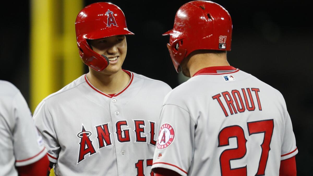 Angels' Shohei Ohtani, left, smiles at Mike Trout after walking in the ninth inning against the Detroit Tigers on Tuesday in Detroit.