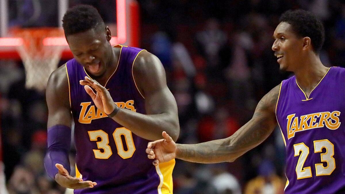 Lakers forward Julius Randle (30) and Lou Williams (23) celebrate their victory over the Bulls on Wednesday night in Chicago.