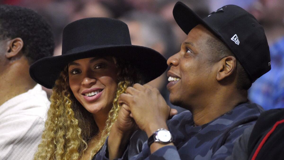 Beyonce and Jay Z watch during the first half of an NBA basketball game between the Los Angeles Clippers and the Oklahoma City Thunder in Los Angeles.