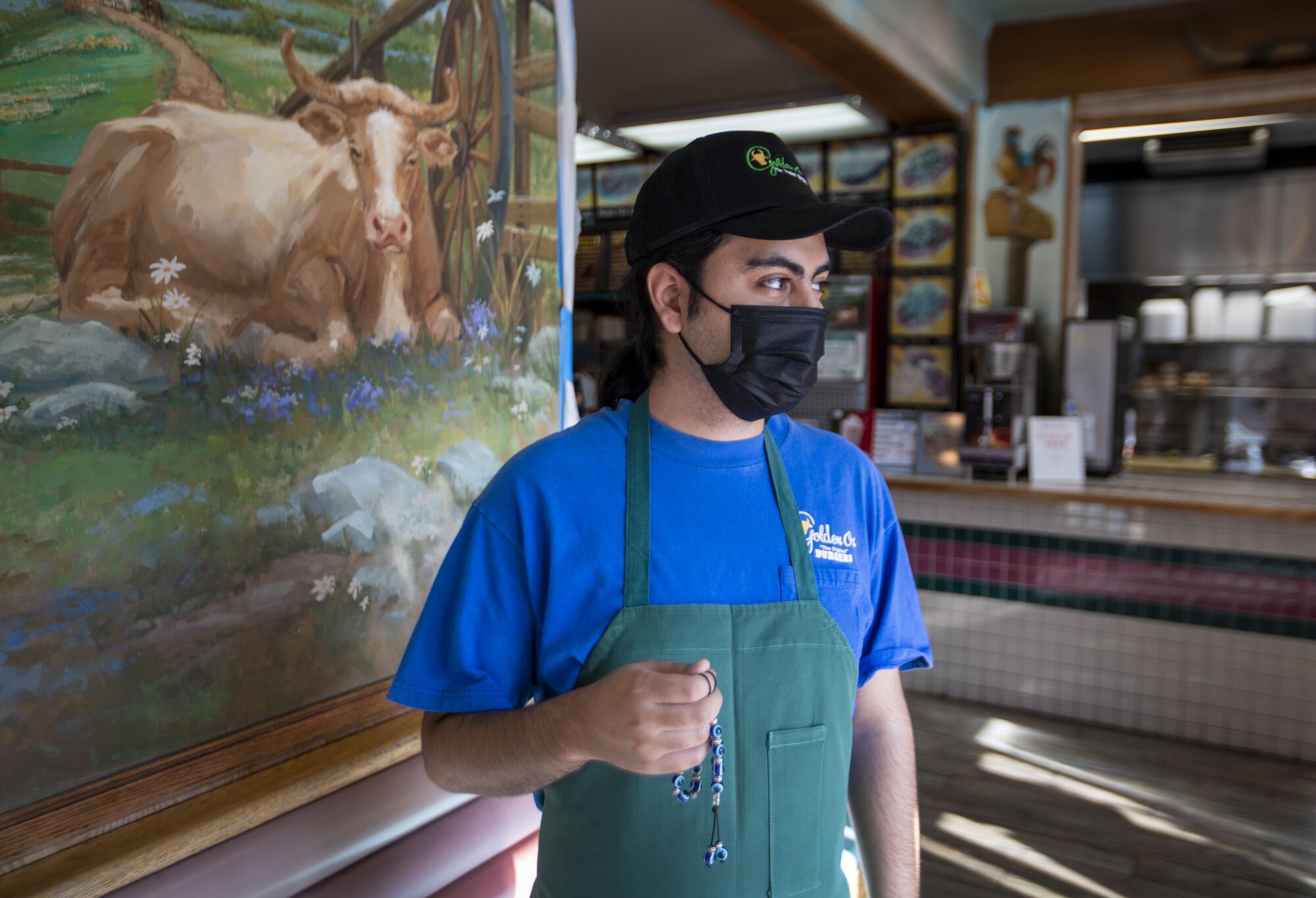 Konstantinos Varelas, manager of Golden Ox Burgers, holds his worry beads while working at the restaurant in El Monte