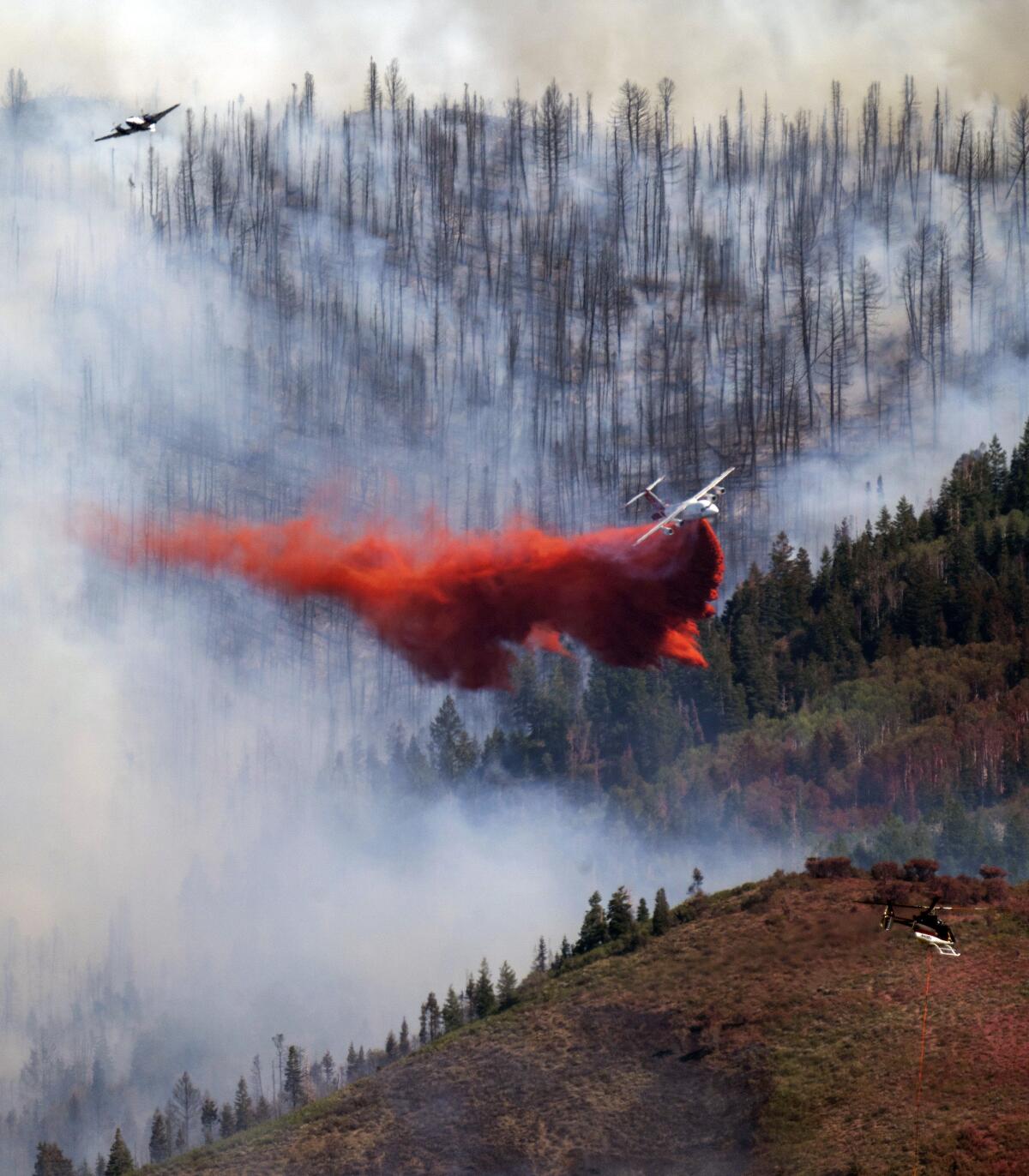 Two planes and a helicopter work on the fire in Parleys Canyon, Saturday, Aug. 14, 2021, in Utah. (Rick Egan/The Salt Lake Tribune via AP)