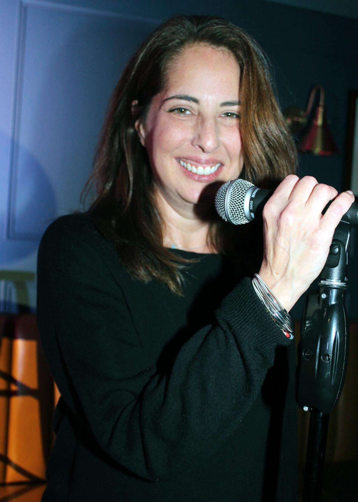 In happier times, Elissa Glickman, chief executive of Glendale Arts, takes over the mic during comedy night at Greyhound Bar & Grill in Glendale this past December.