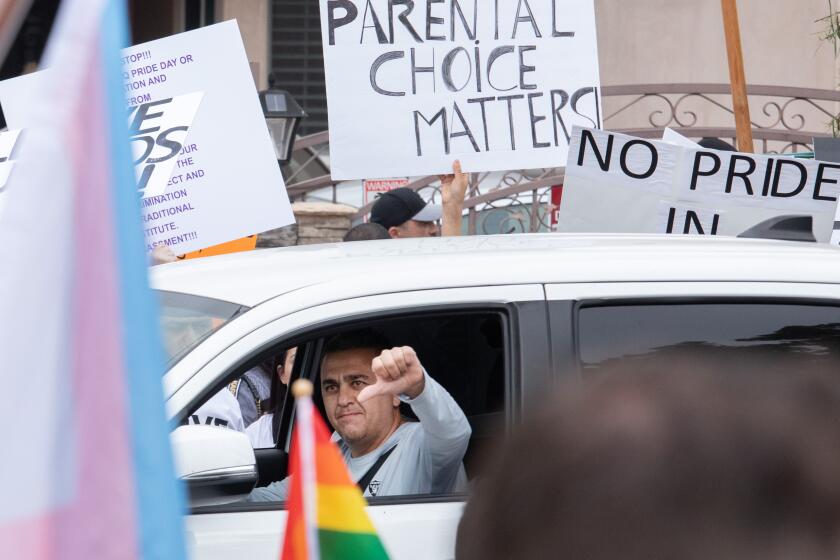 NORTH HOLLYWOOD, CA - JUNE 02: A passing motorist shows his feelings as he passes counterprotesters in front of Saticoy Elementary School on Friday, June 2, 2023. Some parents kept their children home from school to protest the planned Gay Pride and Rainbow Day assembly The parents said they have to right to teach or not teach their children about gay relationships and said that they are too small to be taught this material. They directed their ire at the Los Angeles Unified School District. (Myung J. Chun / Los Angeles Times)