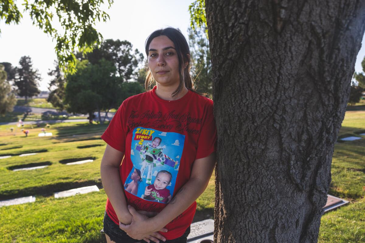 Soluna Lora takes a moment after a gravestone unveiling ceremony for her child who died.