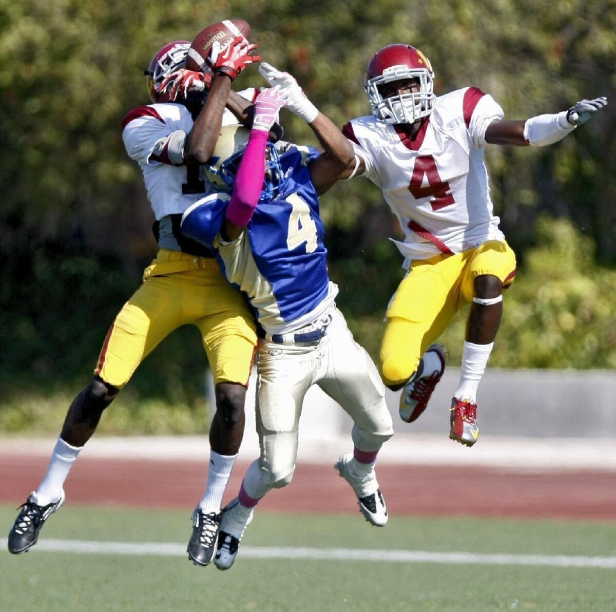 Glendale Community College's Dante Shipman, left, comes down with an interception in a 24-21 victory over West Los Angeles College.