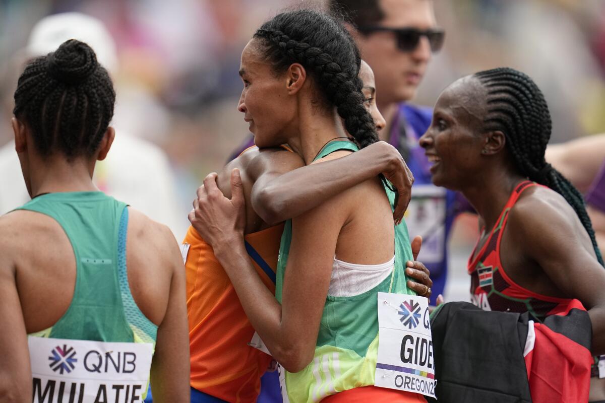 La etiope Letesenbet Gidey abraza a la holandesa Sifan Hassan, 