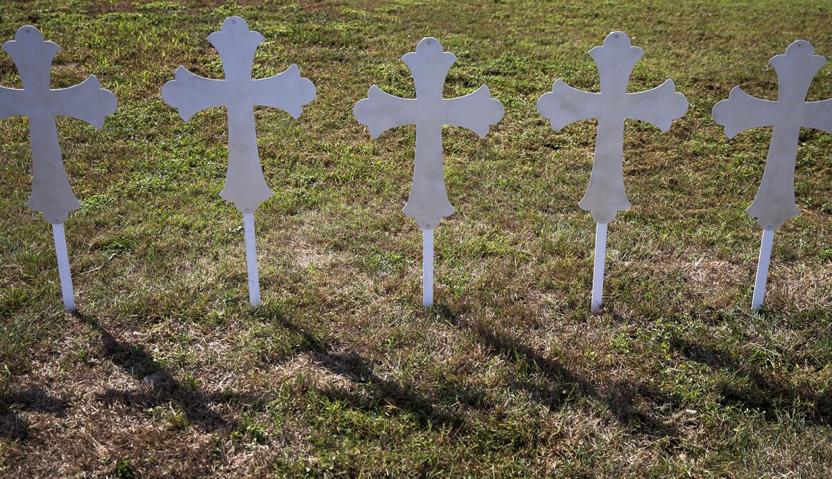 Crosses cast shadows in a grassy area of a gas station in Sutherland Springs, Texas, on Monday.