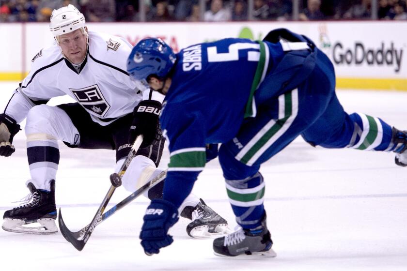 Kings defenseman Matt Greene and Canucks defenseman Luca Sbisa (5) battle for control of the puck during the first period Wednesday night.