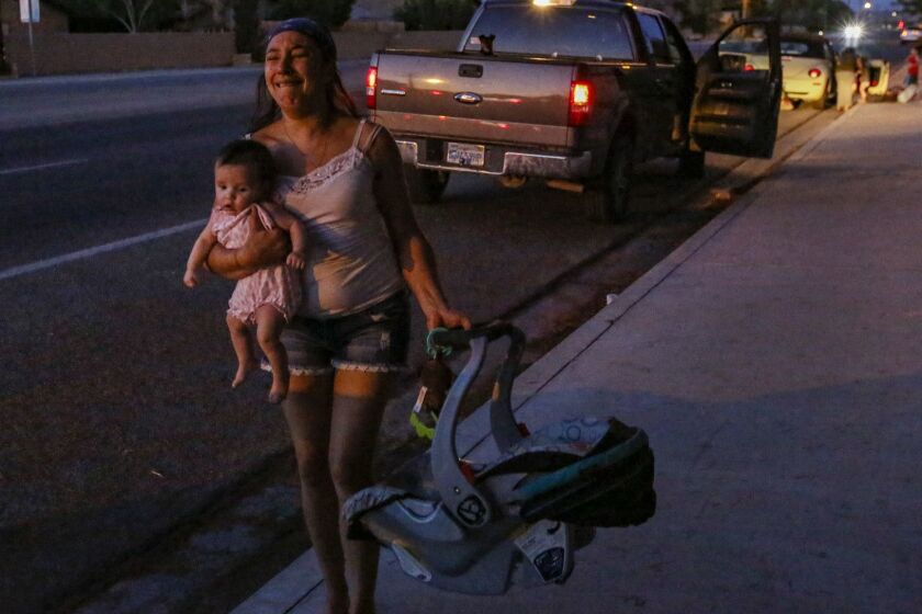 RIDGECREST, CA - JULY 05, 2019 Dawn Inscore is running out her apartment on Ridgecrest blvd. with her child after the Massive earthquake 7.1 hit Ridgecrest. (Irfan Khan / Los Angeles Times)