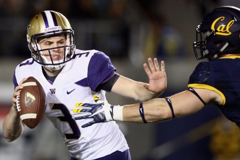 Huskies quarterback Jake Browning is pressured by a California defender during a game on Nov. 5.