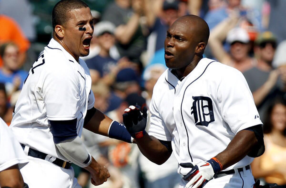 Tigers right fielder Torii Hunter is greeted at home plate by Victor Martinez and other teammates after hitting a three-run, walk-off home run against the A's on Thursday at Comerica Park in Detroit.