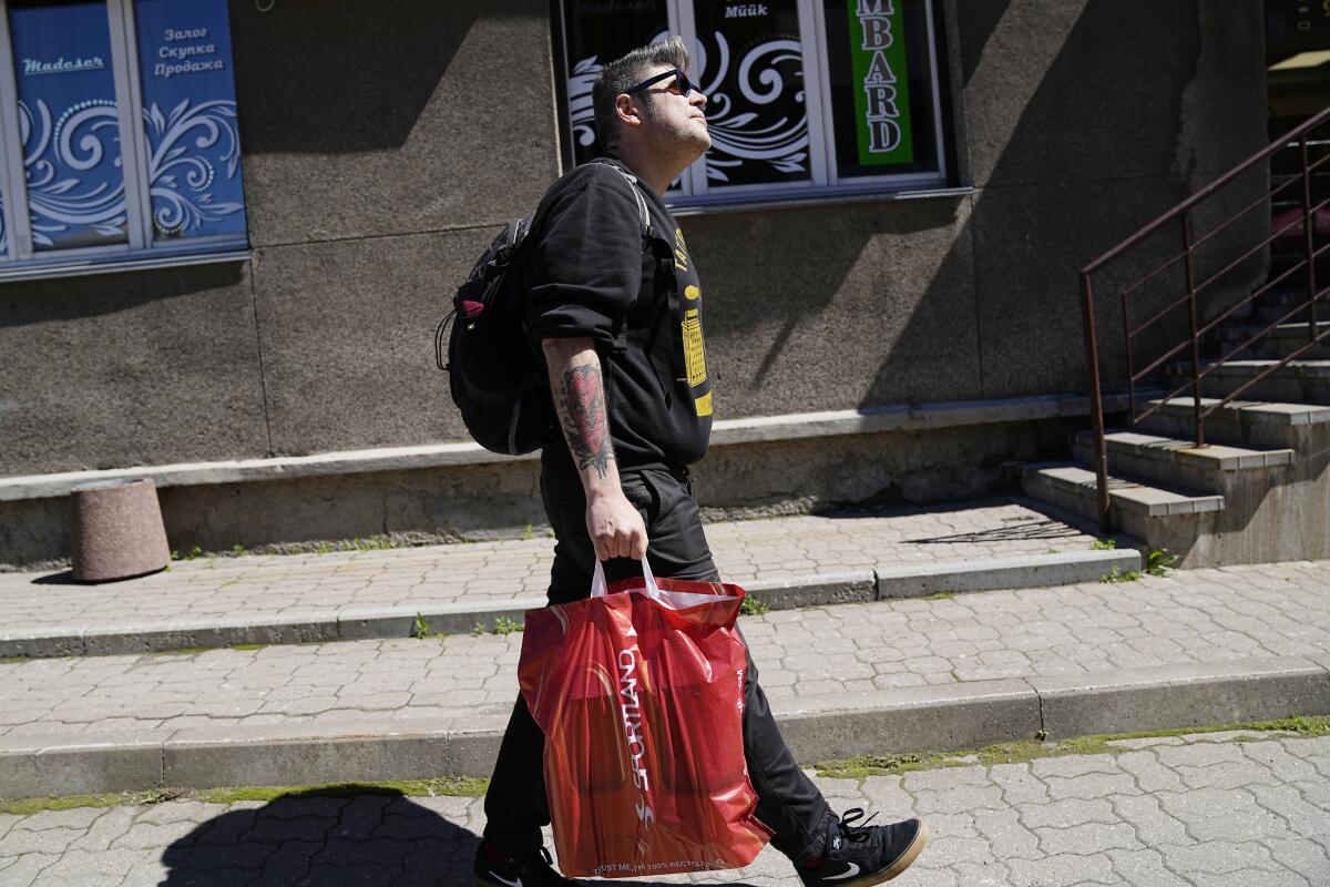 A Russian volunteer holding bags walks through Narva, Estonia.
