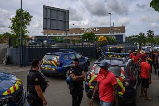 Protesters gather in front of a police cordon outside a Carrefour supermarket amid a cost of living crisis, in Le Francois commune in the French Caribbean island of Martinique on September 21, 2024. Prefect of Martinique announced on September 20 the ban on demonstrations, gatherings and protests in Fort-de-France and three other municipalities on the island until the morning of September 23, after several nights of urban violence, in a context of mobilisation against the high cost of living. (Photo by Ed JONES / AFP) (Photo by ED JONES/AFP via Getty Images)