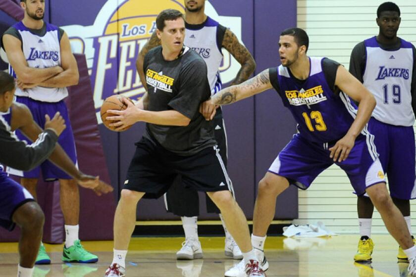 Mark Madsen, center, helps out with the Lakers' summer league camp invitees on July 10 at Toyota Sports Center in El Segundo.