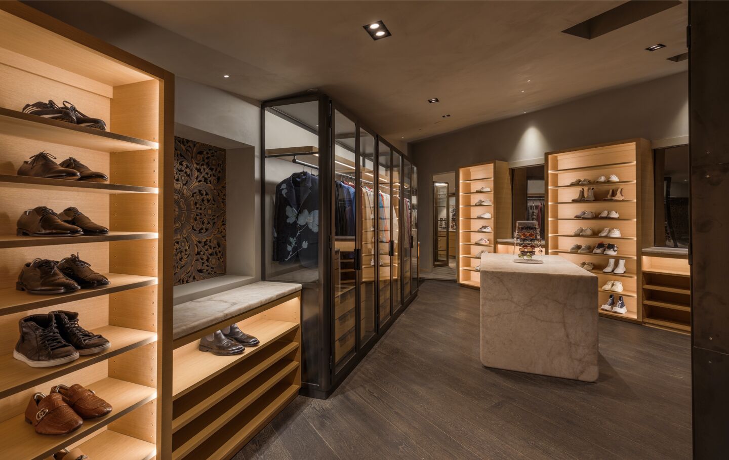 The walk-in closet has many shelves for shoes and other accessories.